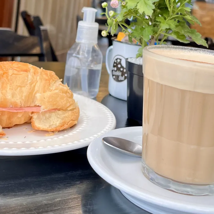 Medialuna e café com leite na mesa da Cookie Sul