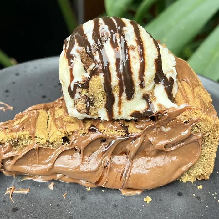 Fatia de torta de cookie com sorvete e calda